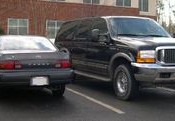 A Ford Excursion Sport Utility Vehicle next to a Toyota Camry